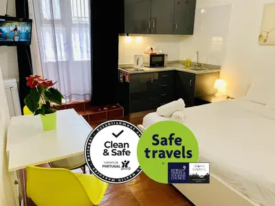 a small apartment with a bed and a table and chairs at Firmeza 358 studios - street level in Porto