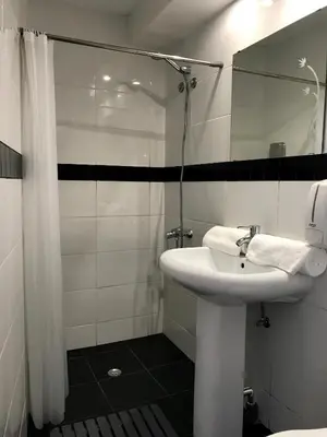 a white bathroom with a sink and a mirror at Firmeza 358 studios - street level in Porto