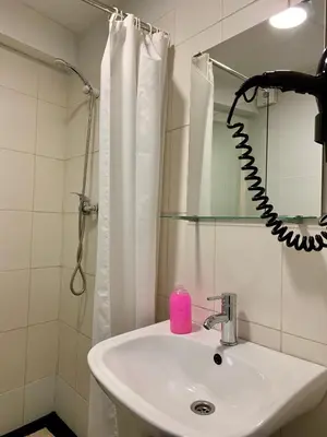 a bathroom with a sink and a pink soap dispenser at Firmeza 358 studios - street level in Porto