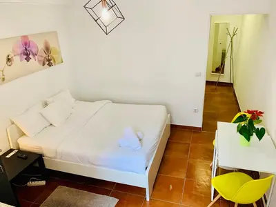 a small bedroom with a white bed and a table at Firmeza 358 studios - street level in Porto