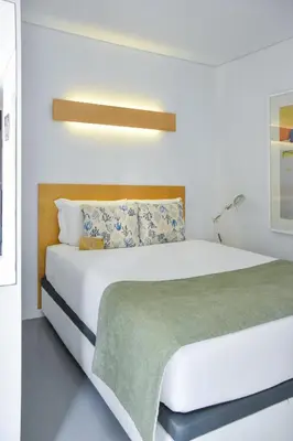 a bedroom with a large white bed with a green blanket at I Loft Porto in Porto