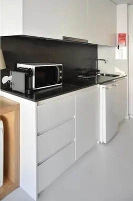 a white kitchen with a microwave on a counter at I Loft Porto in Porto