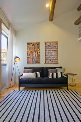 a living room with a blue couch and a rug at Oliveirinhas Porto Apartment in Porto