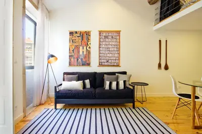 a living room with a blue couch and a table at Oliveirinhas Porto Apartment in Porto