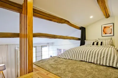 a bedroom with a bed with wooden beams at Oliveirinhas Porto Apartment in Porto