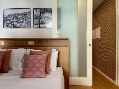 a bedroom with a bed with a wooden headboard at Light-Filled Apartment with Garden • Downtown in Porto