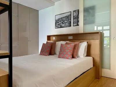 a bedroom with a bed with white sheets and pillows at Light-Filled Apartment with Garden • Downtown in Porto