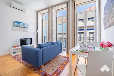 a living room with a blue couch and a table at Bright Apartment • Downtown Porto in Porto