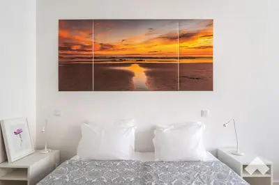 a bedroom with a bed with a sunset over the ocean at Bright Apartment • Downtown Porto in Porto