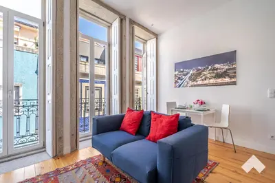 a blue couch in a room with large windows at Bright Apartment • Downtown Porto in Porto