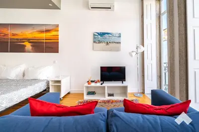 a living room with a blue couch and red pillows at Bright Apartment • Downtown Porto in Porto