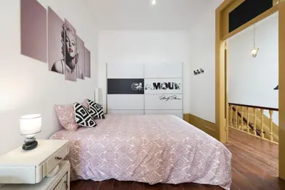 a bedroom with a bed with a pink bedspread at BmyGuest - 156 Trindade House & Terrace in Porto