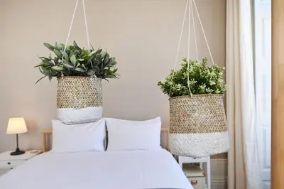 two baskets hanging over a bed with pillows at Inn Oporto Old Town Apartments in Porto