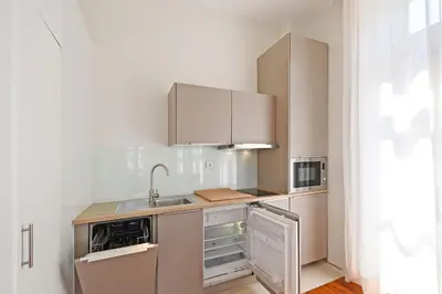a small kitchen with white cabinets and a sink at Inn Oporto Old Town Apartments in Porto