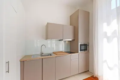 a kitchen with white cabinets and a sink and a microwave at Inn Oporto Old Town Apartments in Porto