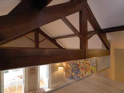 a room with wooden beams and a painting on the wall at Oporto Medusa Apartment in Porto