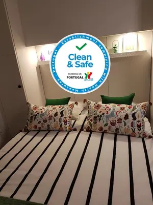 a bedroom with a bed with a sign that says clean and safe at Porto Belo Clérigos in Porto