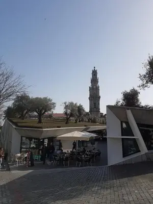 a building with tables and chairs and a clock tower at Porto Belo Clérigos in Porto