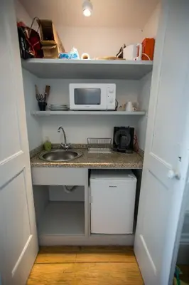 a small kitchen with a sink and a microwave at Casa do Poeta & Guitarra by PCH in Porto