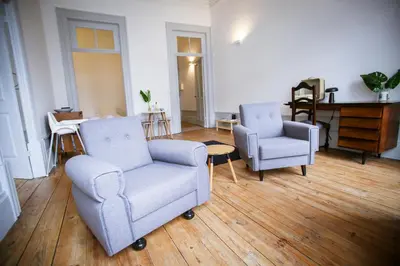 a living room with two chairs and a table at Casa do Poeta & Guitarra by PCH in Porto