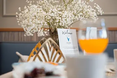 a table with a vase of flowers and a glass of orange juice at Victoria Project - Apartments - Private Parking in Porto