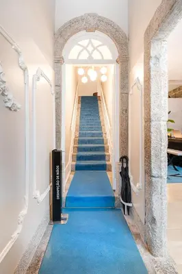 a staircase with blue carpeting and an archway at Victoria Project - Apartments - Private Parking in Porto