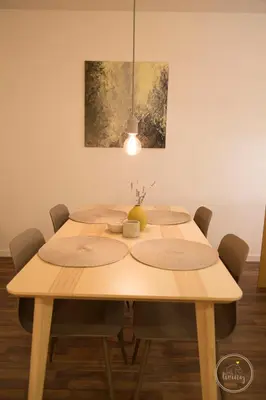 a wooden table with chairs and a painting on the wall at Hello Porto Ceuta Residences in Porto