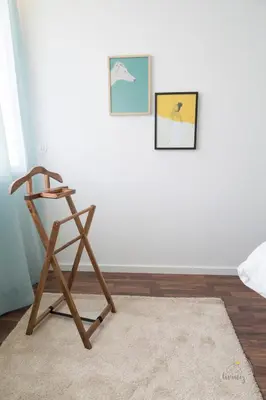 a wooden chair in a room with two pictures on the wall at Hello Porto Ceuta Residences in Porto