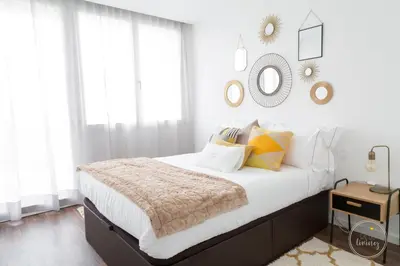 a bedroom with a bed with white walls and windows at Hello Porto Ceuta Residences in Porto