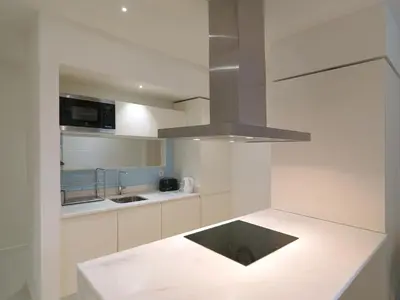 a kitchen with white cabinets and a stove top oven at FLH Porto Central Apartment in Porto
