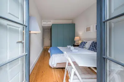 a small bedroom with a bed and a window at Casa do Ofício - Caldeireiro in Porto