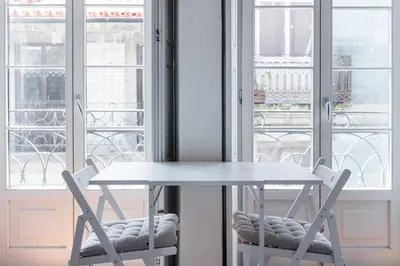 a table and two chairs in front of a window at Casa do Ofício - Caldeireiro in Porto