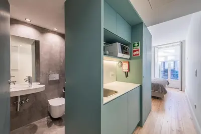 a bathroom with a sink and a toilet and a bed at Casa do Ofício - Caldeireiro in Porto