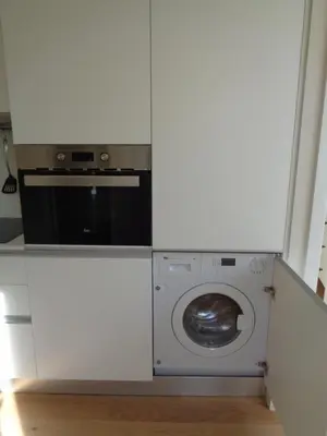 a kitchen with a microwave and a washing machine at Secret Camões in Porto