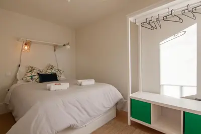 a bedroom with a white bed and a mirror at Secret Camões in Porto