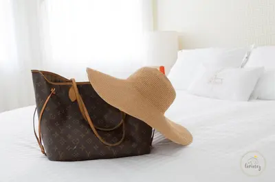 a straw hat sitting on a bed with a purse at Oporto Ceuta Residences - Residence 2 by We Do Living in Porto