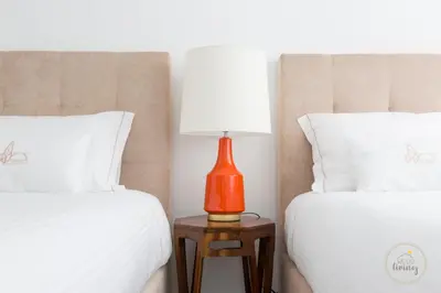 an orange lamp sitting on a table between two beds at Oporto Ceuta Residences - Residence 2 by We Do Living in Porto