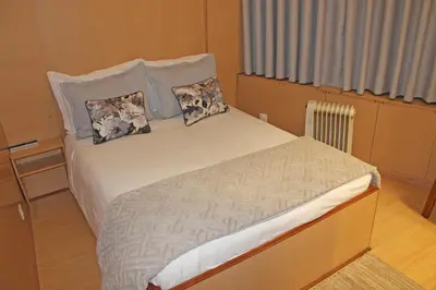 a bed with two pillows on it in a room at Residencial Paranhos in Porto