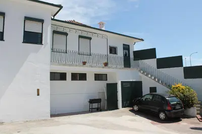a black car parked in front of a white building at Residencial Paranhos in Porto
