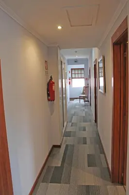a hallway with a fire extinguisher on the wall at Residencial Paranhos in Porto
