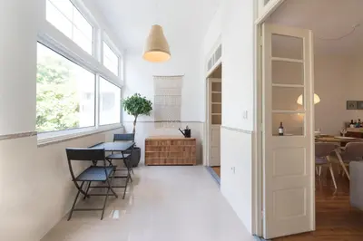 a room with white walls and a table and chairs at Tripas-Coração, Breiner GreenHouse in Porto