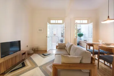 a living room with a couch and a television at Tripas-Coração, Breiner GreenHouse in Porto