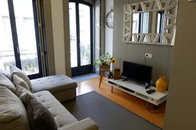 a living room with a couch and a flat screen tv at Porto Urban Art Trindade in Porto