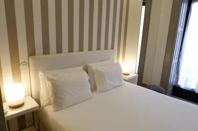 a bedroom with a bed with two pillows and two lamps at Porto Urban Art Trindade in Porto