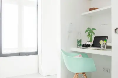 a white room with a blue chair and a laptop at Porto Moments Apartments by Portugal Collection in Vila Nova de Gaia