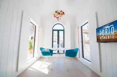 a dining room with a table and blue chairs at Porto Moments Apartments by Portugal Collection in Vila Nova de Gaia