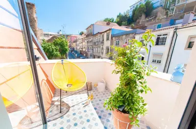 a balcony with a yellow umbrella and some plants at Porto Moments Apartments by Portugal Collection in Vila Nova de Gaia