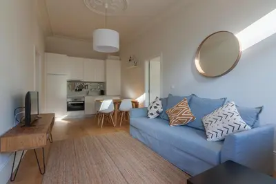 a living room with a blue couch and a mirror at Terrace Camões in Porto