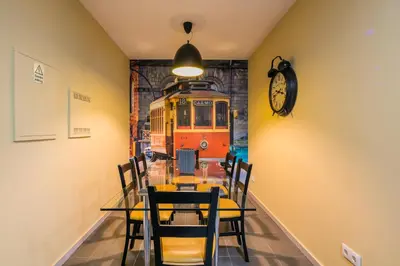 a dining room with a table and a train on the wall at Camarinha Oporto Apartments in Porto