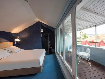 a bedroom with a bed and a balcony at Apartamentos The Arc Carrís in Porto